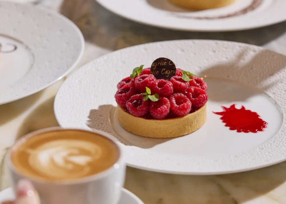 A custard tart topped with raspberries on top