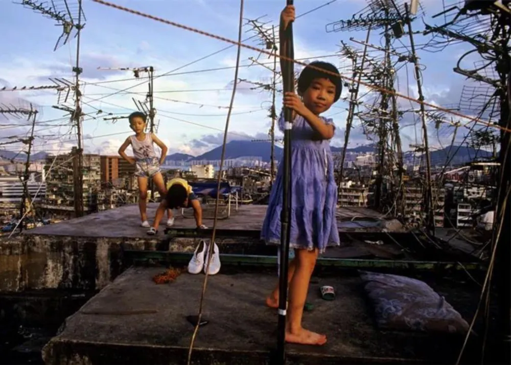 Girl posing with satellite on roof, photographed by Greg Girard, Hong Kong