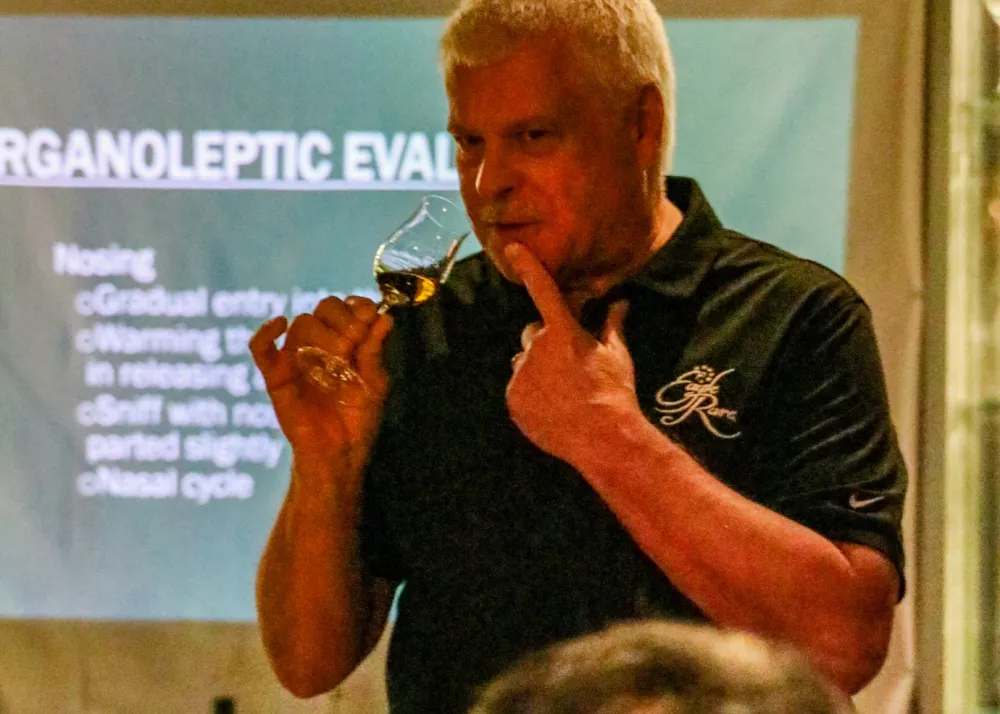 a person holding a whiskey nosing glass
