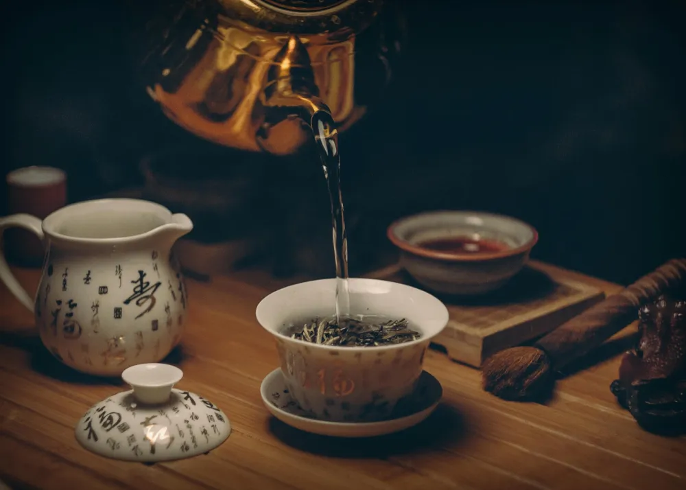 A golden teapot with a tea cup
