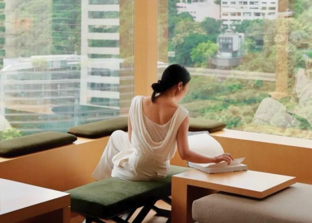 Upper House Room Interior elegantly dressed woman enjoying views of Hong Kong