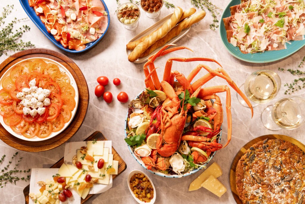A shared dining spread — lobster, pasta and small plates