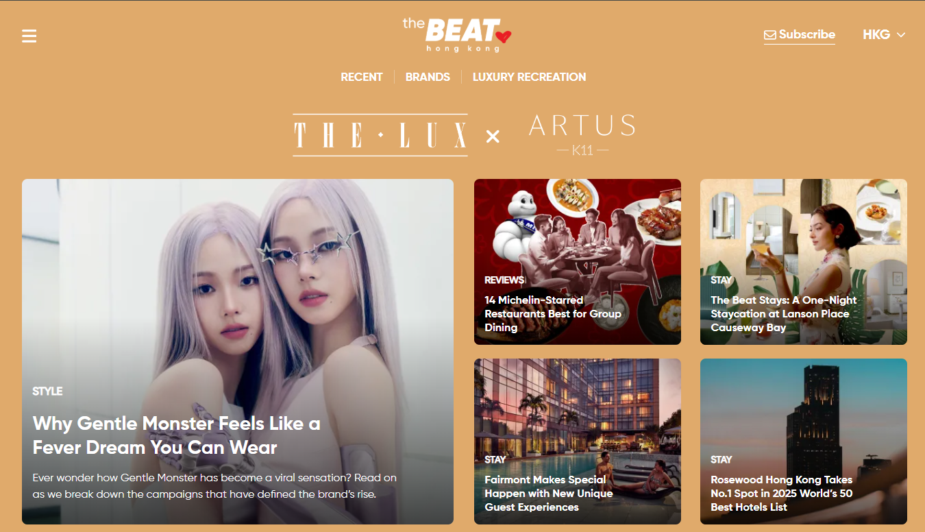 Website homepage for The Beat features articles, with two women on the main image. Other images show people dining, a hotel room, a festive market, and a street view, under categories like Reviews and Style.