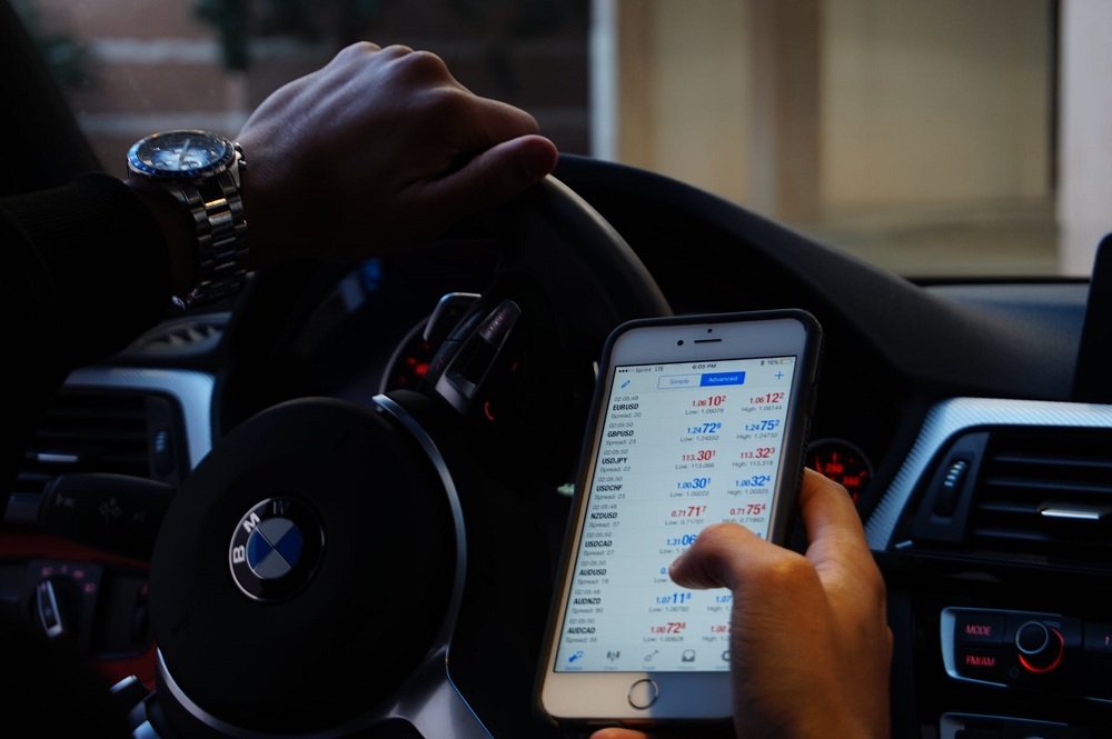 A person in a car while scrolling on their phone