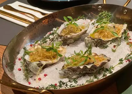 grilled oyster with garnish served on a platter with salt granules at charcoal bar hong kong