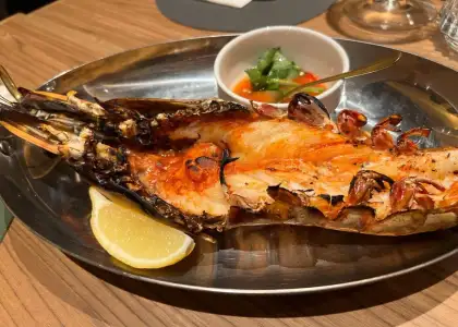 grilled prawn served on a platter with a wedge of lemon at charcoal bar hong kong