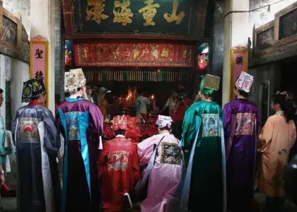 crowd in traditional clothing religious worship at chinese temple hung shing festival