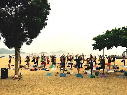 group of people doing yoga on the beach