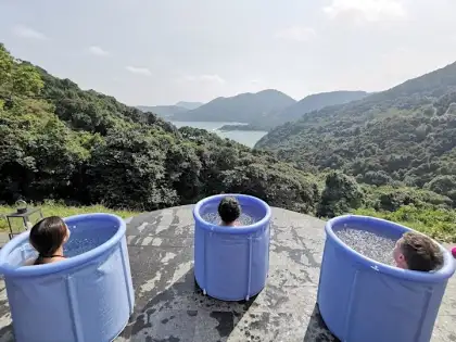 people in a tub by a cliff