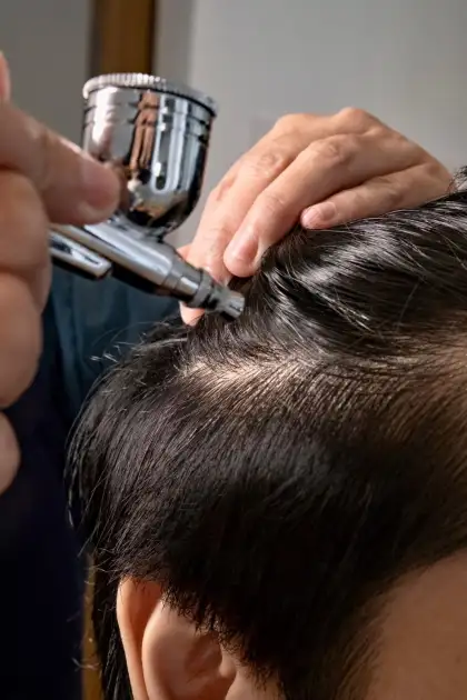 Herb tonic is sprayed throughout the scalp