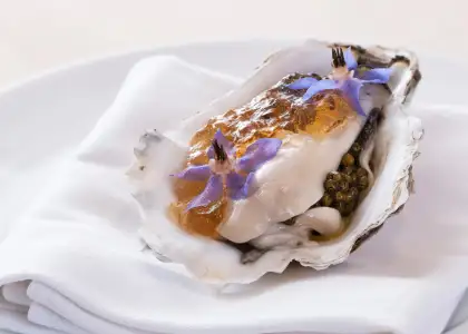 oyster with sauce and flower garnish