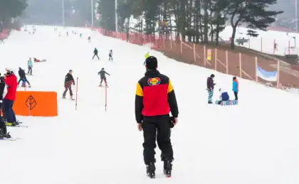Man In Red Jacket Standing At Snowy Icy Ski Resort