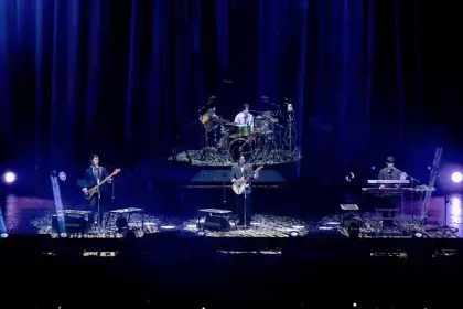 DAY6 members YoungK (left), Sungjin (center), Dowoon (center, back), and Wonpil (right)