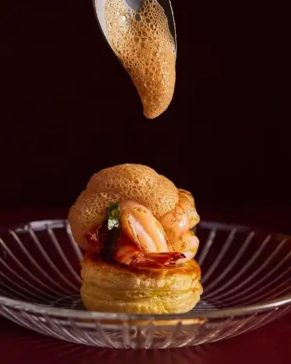 Black tiger prawn tart with slow-cooked caramelised onion and bisque foam