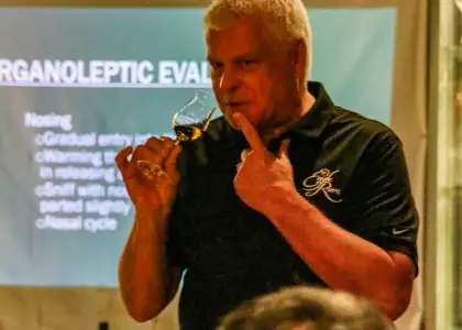 a person holding a whiskey nosing glass