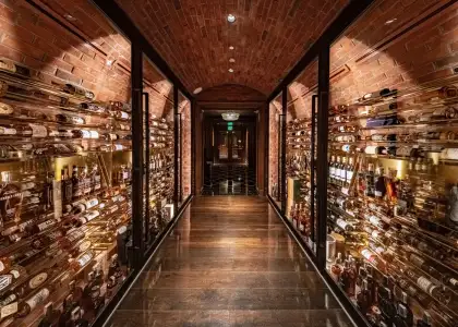 a lit hallway with bottles on the sides
