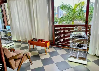 image of pop-up vinyl audio library by V Music HK overlooking views of palm trees at Murray House, Stanley