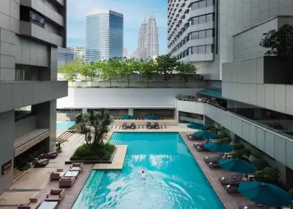 doubletree by hilton kuala lumpur hotel,a pool in the middle with a person swimming on it overlooking the twin  towers