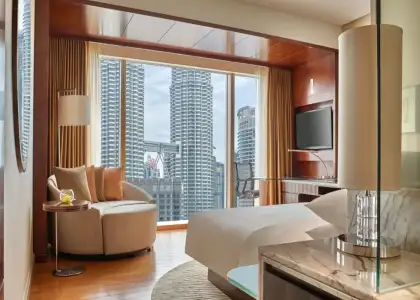 grand hyatt kuala lumpur room view with bed and chair overlooking the petronas tower