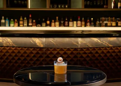 A cocktail with a bar counter at the background