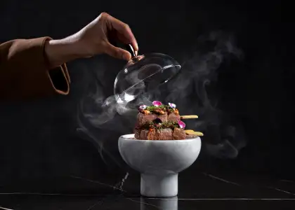 a hand reaching for skewers