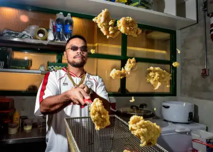 A person cooking fried chicken stylishly