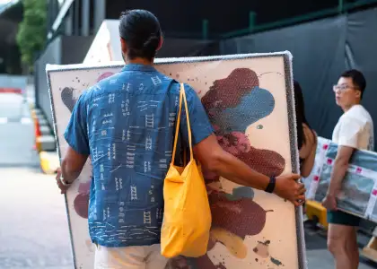 A man carrying a painting he bought