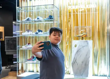 A young fan taking a selfie with The Legacy Wall