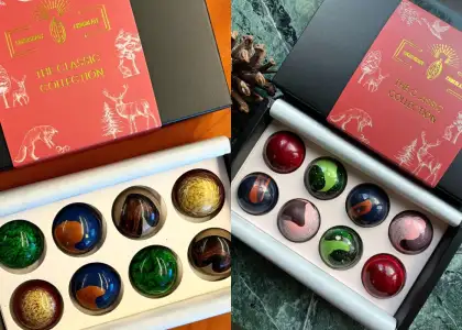 A decorative box of assorted chocolates featuring various intricate designs on its exterior.
