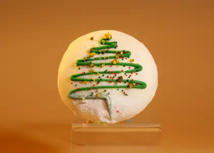 A pistachio cream donut with a Christmas tree design