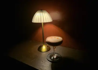 A cocktail with a lamp at the back