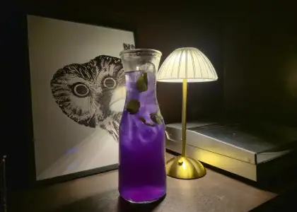 A violet colored cocktail in a pitcher