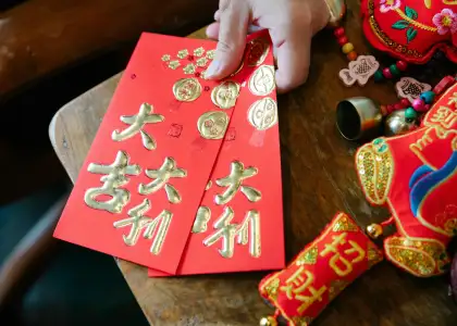 A photo of a woman holding red envelopes