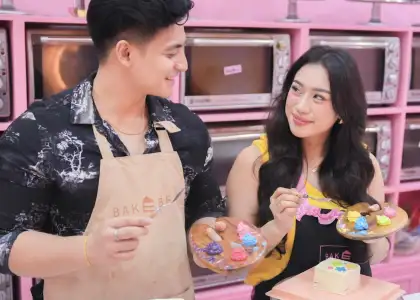A photo of a couple decorating a cake together