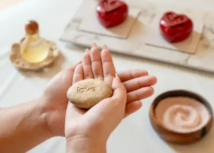 a close-up, eye-level shot focused on a pair of hands holding a smooth, oval, light brown stone