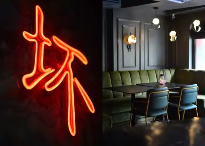 A neon sign of a Chinese character and interior of a restaurant