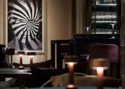 A visual illusion artwork at the background with tables and lamps