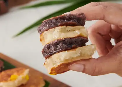 A hand holding four pieces of dessert