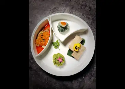 A plate featuring four distinct dishes, showcasing a variety of colors and textures.