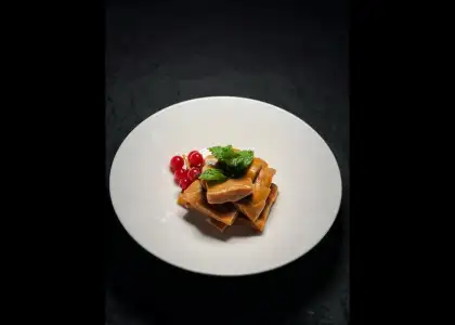 A plate featuring tofu cubes alongside a mix of fresh berries, showcasing a colorful and healthy meal option.