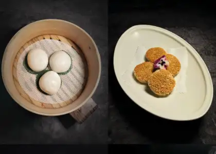 A table set with two plates of food and a bowl containing more food items.