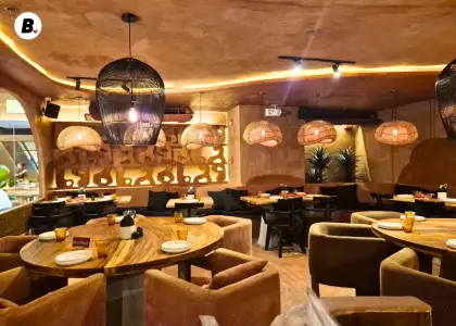 A restaurant with warm lights, brown wood seating