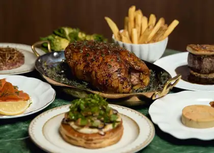 A plate of cooked fish accompanied by colorful vegetables, elegantly arranged on a dining table.