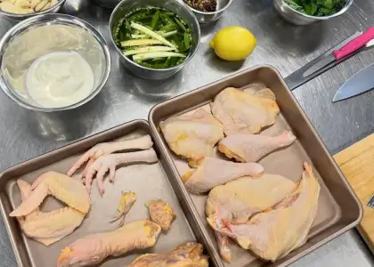 Ingredients for chicken displayed in pans, indicating the initial steps of meal preparation.