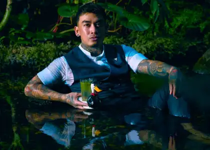 Ryan Dela Vega, Bar Beverage Manager of Aqua Bangkok posed in Aqua's pond with cocktail