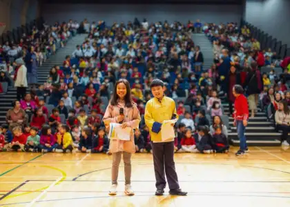 Student MCs smiling and posing in front of audience at Chinese International School - best Hong Kong International Schools - The Beat Asia