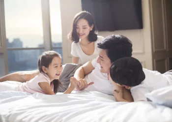 Cheerful young family having fun on a bed 2024 10 16 11 23 52 utc