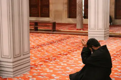 man praying to God in the Sultan Ahmet Mosque