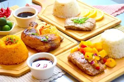 Filipino grilled dishes with fried rice and sauce.