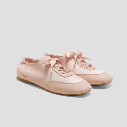 A pair of pink Vivaia Ballerina shoes featuring decorative bows on the sides, designed for a stylish and playful look.